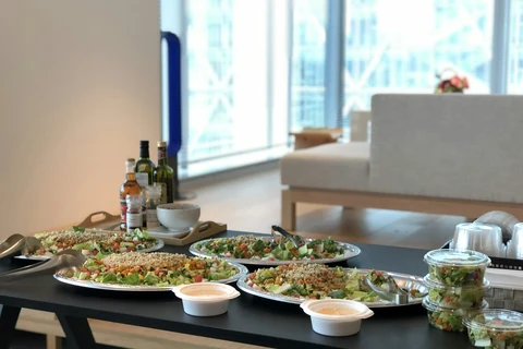 Plated lunches laid out along a table in a bright office