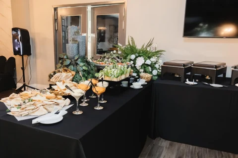 A reception buffet with champagne flutes, white florals and greenery