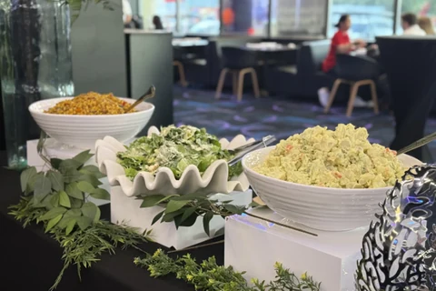 A food display with fresh greenery and white serving dishes