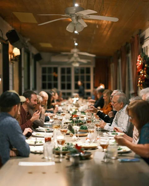 Guests dining together at a long table in a bright room