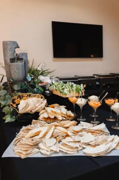 A buffet spread of dips, pita and salads on black linen