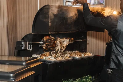 A large roast being carved over a grill