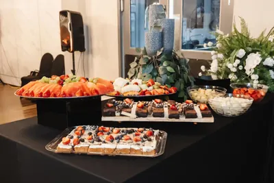 A dessert display of tarts and berries on a dark table