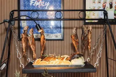 A carved fish display hung above a serving board of breads and salmon