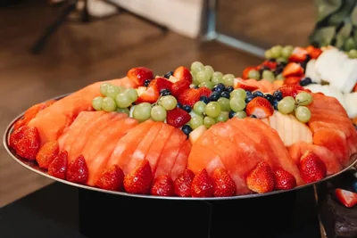 A carved watermelon platter with strawberries and grapes