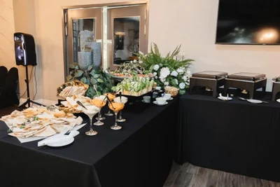 A reception buffet with champagne flutes, white florals and greenery