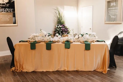 A buffet table dressed in gold linen with a floral centrepiece