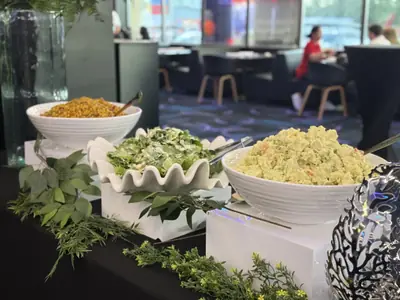 A food display with greenery and white serving dishes