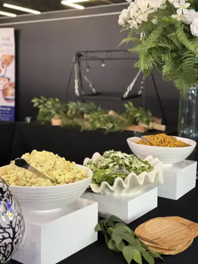 A buffet of rice dishes in white bowls with greenery