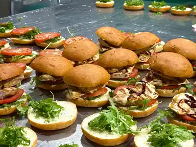Rows of grilled chicken sliders with arugula and tomato on brioche buns