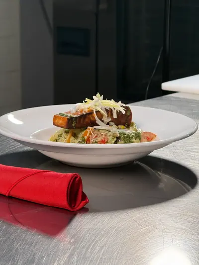 A plated main course on a white plate with a red napkin