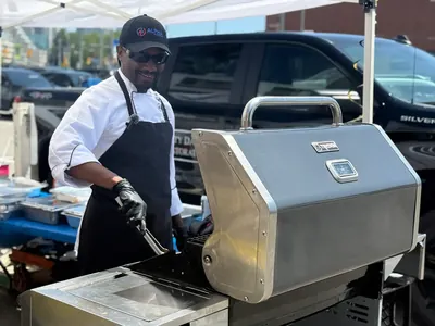 An Alpha Katering chef loading catering equipment for an outdoor event