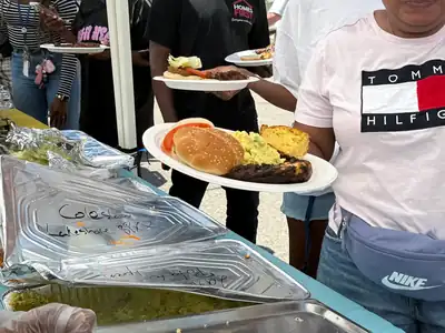 Servers handing plated meals across a buffet line